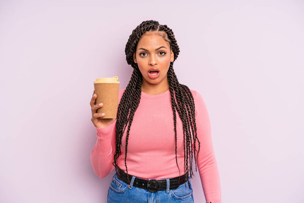 black afro woman looking very shocked or surprised. take away coffee - Foto, afbeelding