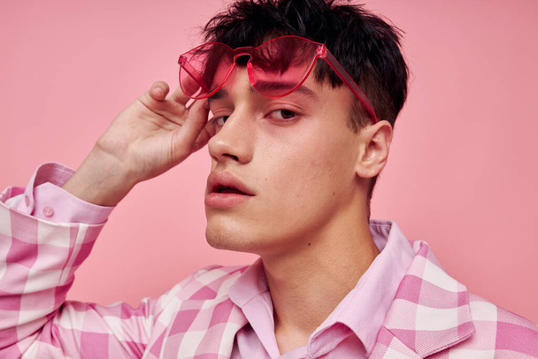 A young man fashionable pink sunglasses jacket posing pink background unaltered - Valokuva, kuva