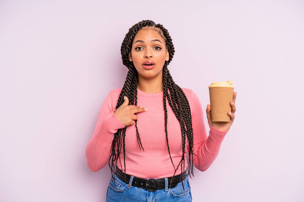 чорна афро-жінка виглядає шокованою і здивованою відкритим ротом, вказуючи на себе. заберіть каву
 - Фото, зображення