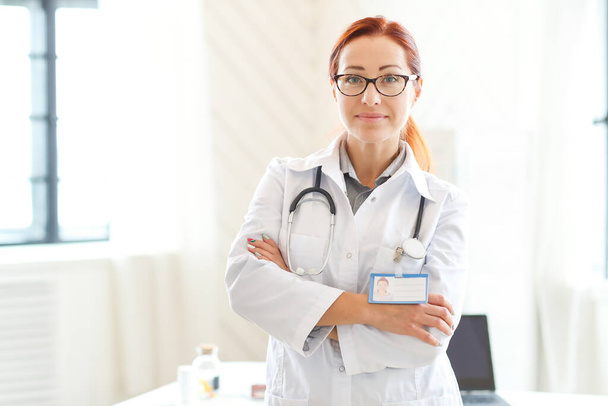Hospital and medicine concept. Woman doctor with ginger hair working at clinic - 写真・画像