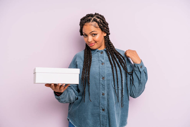 musta afro nainen näyttää ylimielinen, onnistunut, positiivinen ja ylpeä. paketit laatikko käsite - Valokuva, kuva