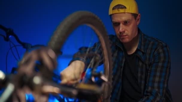 Technician calibrates the wheel of the bicycle. Bicycle repair workshop. - Materiaali, video