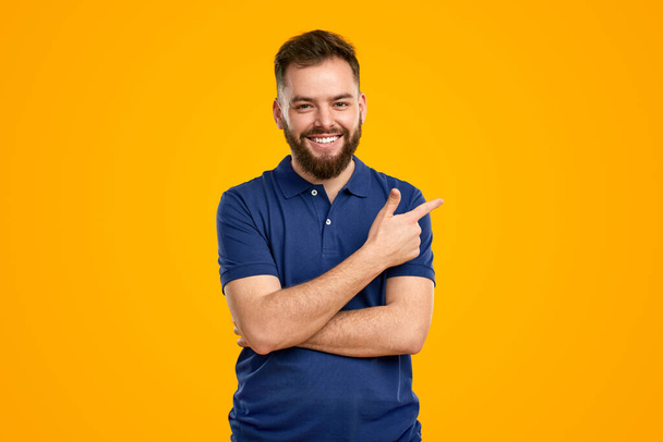 Cheerful man pointing aside in studio - Photo, Image