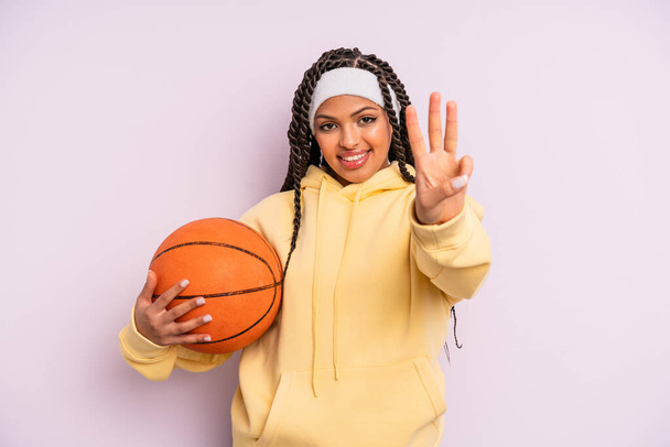 black afro woman smiling and looking friendly, showing number three. basketball concept - Photo, image