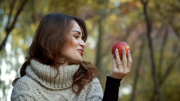 Kobieta z apple w parku - Materiał filmowy, wideo