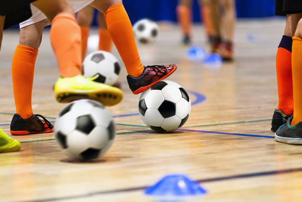 Шкільний футбольний клас для дітей у спортивному залі. Діти копають футбольні м'ячі на Вуденській підлозі. Футбольна практика для хлопчиків - дошкільнят - Фото, зображення