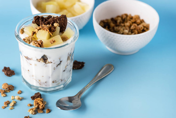 Glass of Diet Dessert with Yogurt Muesli or Granola Diet Cookies with Oatmeal and Fruit Blue Background Healthy Diet Breakfast Horizontal - Foto, Bild