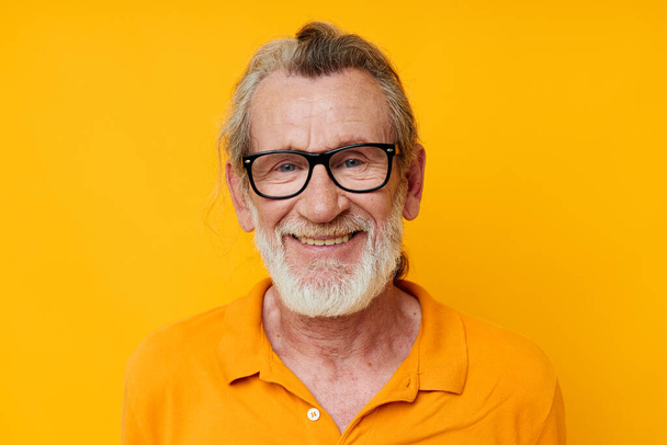cheerful old man gray beard glasses yellow background - Fotó, kép