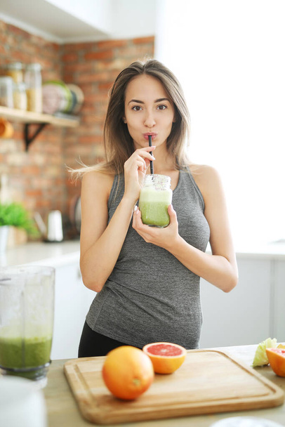 Happy young food vlogger drink smoothie in the kitchen - Foto, afbeelding