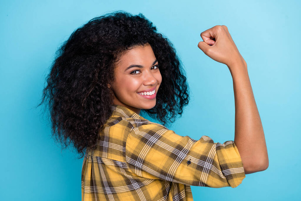 Photo of confident strong lady raise hand show biceps wear checkered shirt isolated blue color background. - Photo, Image