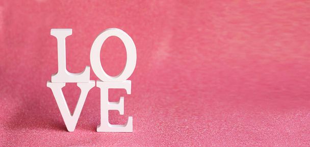 The word LOVE made of white letters on a light pink background with bokeh, Valentine's Day, lovers' holiday - Foto, Imagem