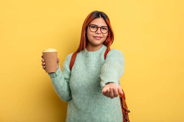 hispanic woman smiling happily with friendly and  offering and showing a concept. student with a coffee concept - Fotoğraf, Görsel