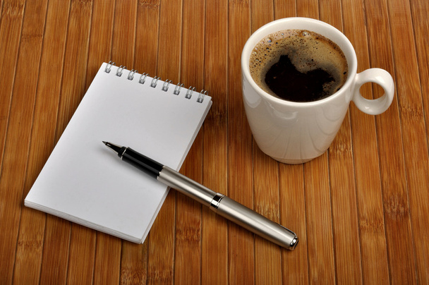 Notebook with a pen and a cup of coffee - Фото, зображення