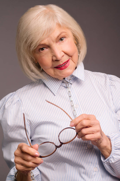 Stylová starší žena v bílé blůze vypadá sebevědomě - Fotografie, Obrázek