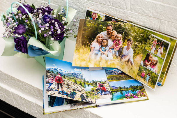 fehér asztalon nyitott fotózás családi fotózás. az élet fontos pillanatainak megőrzése a fotóalbumon. fotós és tervező munkájának eredménye. poligráfia. - Fotó, kép