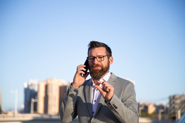 handsome businessman with phone in the city - Foto, afbeelding