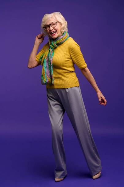 Vanhempi nainen keltainen paita ja vihreä huivi tunne energinen - Valokuva, kuva