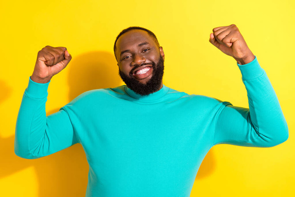 Portrait of delighted glad man raise fists accomplishment toothy smile isolated on yellow color background - Fotografie, Obrázek