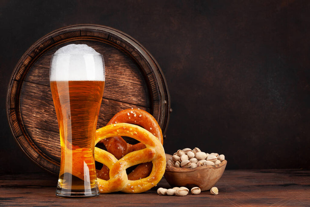 Birra Lager con pretzel fatti in casa e vecchia botte di birra in legno. Con spazio di copia - Foto, immagini