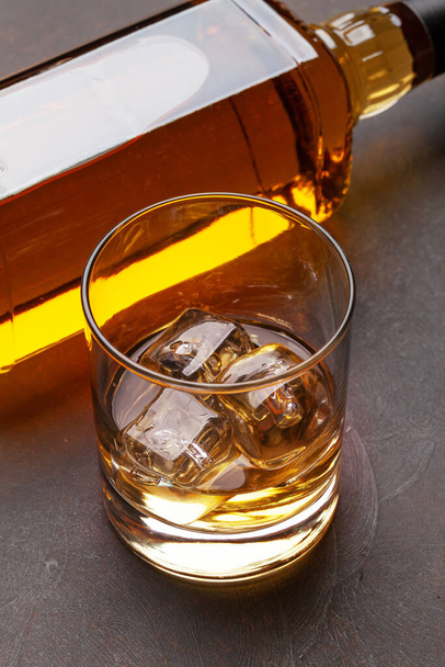 Scotch μπουκάλι ουίσκι και ποτήρι σε πέτρινο τραπέζι - Φωτογραφία, εικόνα