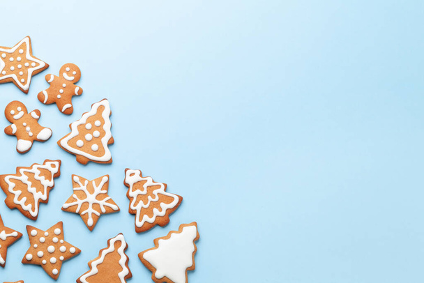 Tarjeta de Navidad con galletas de jengibre sobre fondo azul. Vista superior plano con espacio para saludos de Navidad - Foto, imagen