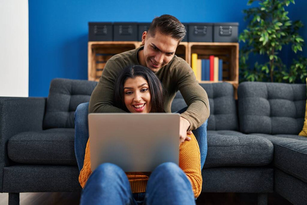 mężczyzna i kobieta para przytulając się za pomocą laptopa w domu - Zdjęcie, obraz