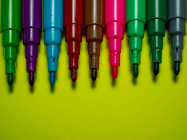 Colored markers on yellow background. Colored felt-tip pen. - Фото, изображение