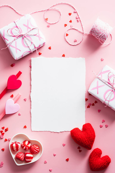 Happy Valentines Day composition. Blank greeting card mockup, gift boxes, red hearts, confetti on pink background - Foto, imagen