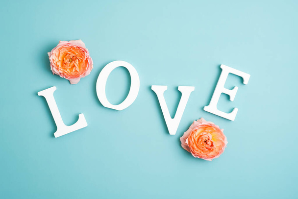 Word Love and flower buds on blue background. Happy Valentines Day concept. - Fotografie, Obrázek