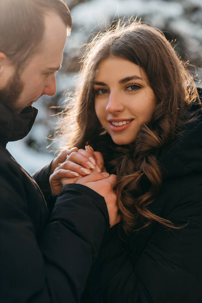 Un hombre gentilmente calienta las manos de su amada niña en clima frío - Foto, imagen