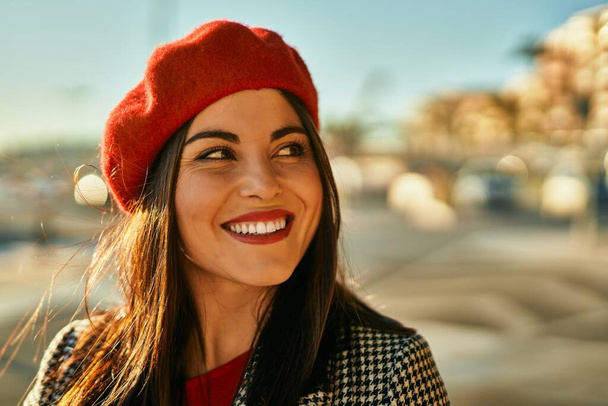 Young hispanic woman smiling happy standing at the city. - 写真・画像