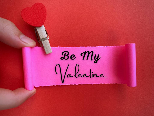 Be my valentine text on ripped paper with red paper background. Valentines Day concept. - Photo, image