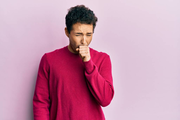 Pohledný hispánský muž v neformální oblečení přes růžové pozadí pocit nevolnosti a kašel jako symptom pro nachlazení nebo zánět průdušek. koncepce zdravotní péče.  - Fotografie, Obrázek