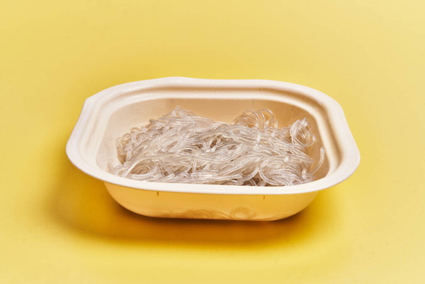  Delivery tray of white rice noodles over yellow background - Zdjęcie, obraz
