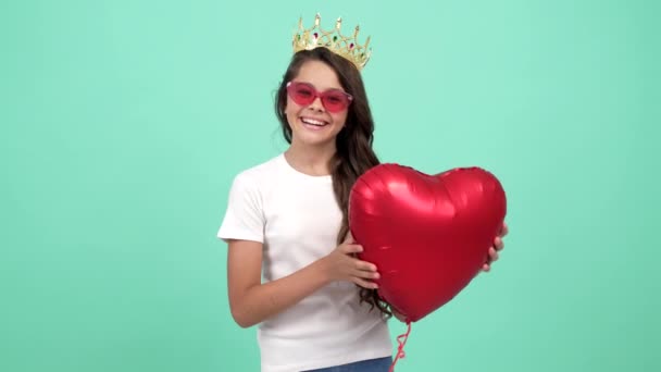 happy teen girl winner in sunglasses and queen crown with heart party balloon, pageant - Кадры, видео
