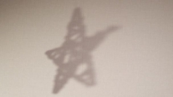 La silueta abstracta rota el fondo de sombra de la estrella que cae en la pared. Sombra borrosa transparente del juguete de Navidad con lugar para el texto. Imágenes de vídeo 4k para superposición en el fondo y maqueta - Imágenes, Vídeo