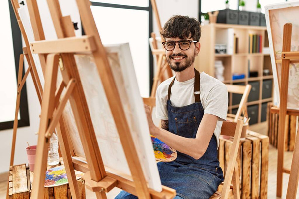 Nuori latino taiteilija mies hymyilee onnellinen piirustus art studio. - Valokuva, kuva
