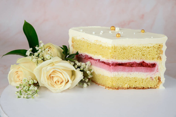 Festive cut sponge cake with strawberry filling with white roses. - Φωτογραφία, εικόνα