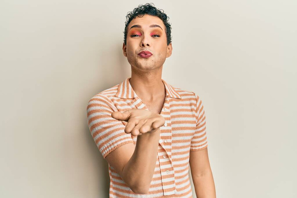 Handsome man wearing make up wearing casual t shirt looking at the camera blowing a kiss with hand on air being lovely and sexy. love expression.  - Foto, immagini