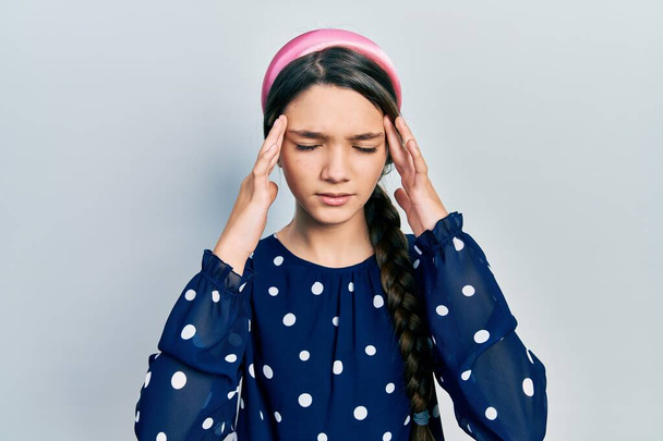 Young brunette girl wearing elegant look with hand on head for pain in head because stress. suffering migraine.  - Foto, Imagen