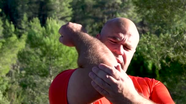 スローモーションの男は肘の痛みを訴え - 映像、動画
