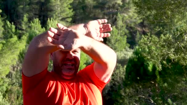 Slow motion, the man asks for help in the forest by opening and closing his arms - Video