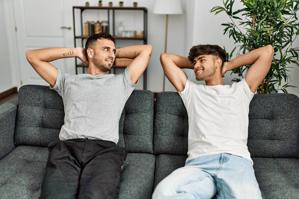 Two hispanic men couple smiling confident relaxed with hands on head at home - Zdjęcie, obraz