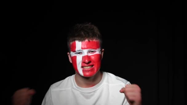 Happy fan celebrate victory of his team. Young man with face painted in national colours. Portrait of a happy man supports his national team at home - Footage, Video