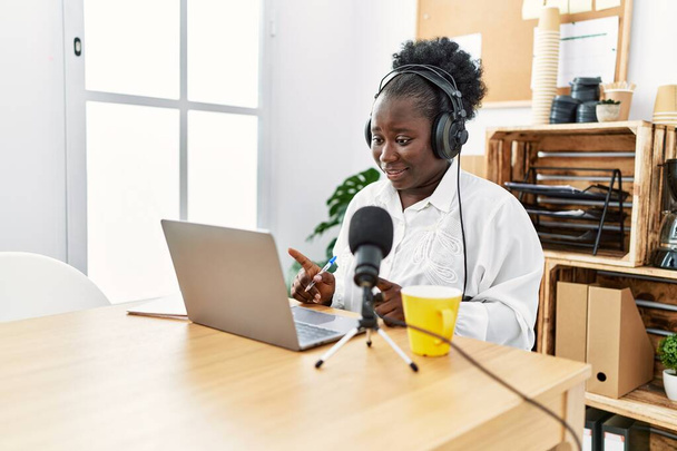 Jeune diffuseuse afro-américaine souriante confiante travaillant au studio de radio - Photo, image