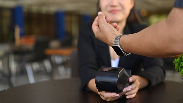 Gehakt beeld van de klant betalen door middel van slimme horloge bij coffeeshop. - Foto, afbeelding