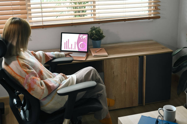 Side view alkalmi üzletasszony ül otthon iroda és dolgozik a számítógép tabletta. - Fotó, kép