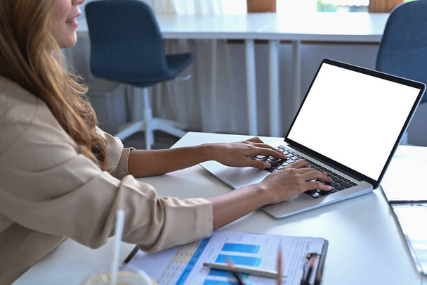 Mujer de negocios sentada en el escritorio de su oficina y usando computadora portátil. - Foto, imagen