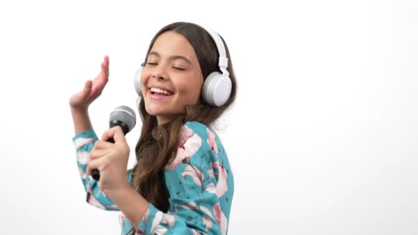 happy kid singer listen music in headphones and sing in microphone imagine herself star, childhood. - Video