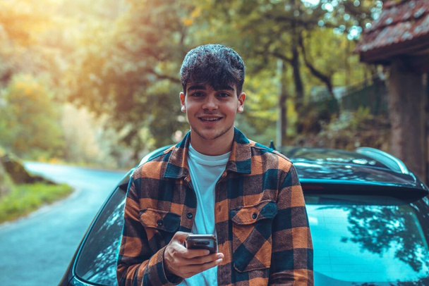 young man outdoor mobile phone leaning on the car - Foto, Bild